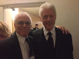Two men in suits and ties posing for a picture.