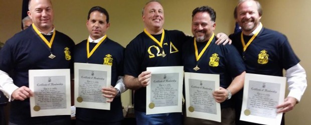 A group of men holding certificates and medals.