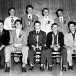 A group of men sitting in chairs posing for a picture.